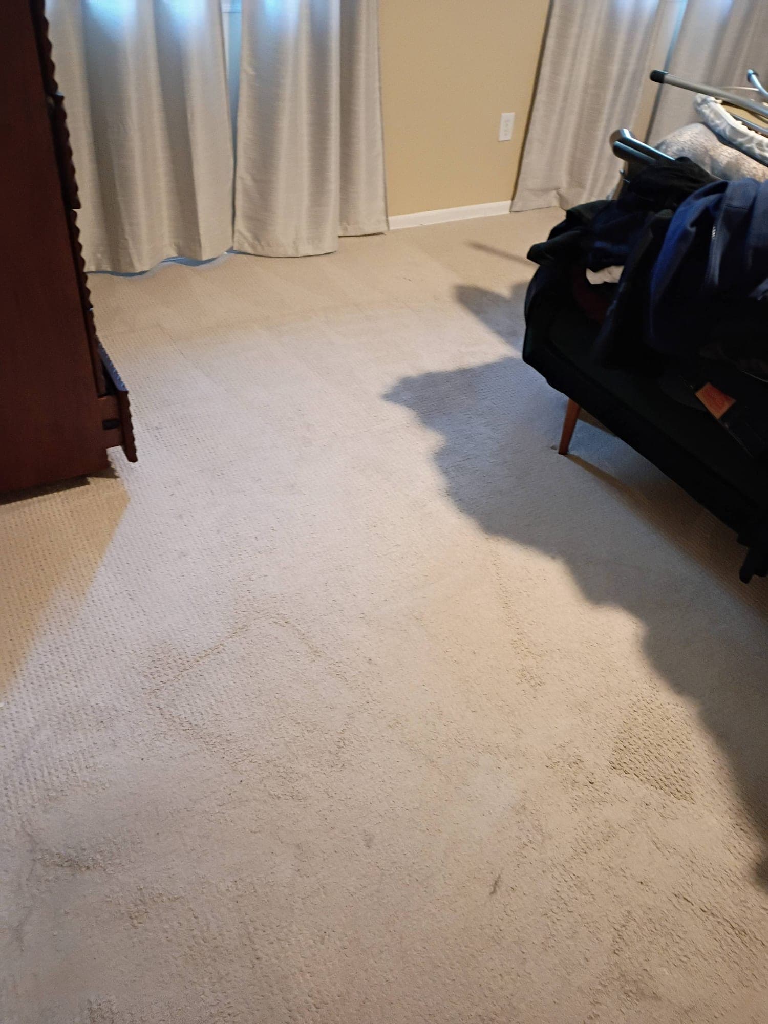 Bedroom carpet after professional cleaning with curtains and luggage nearby
