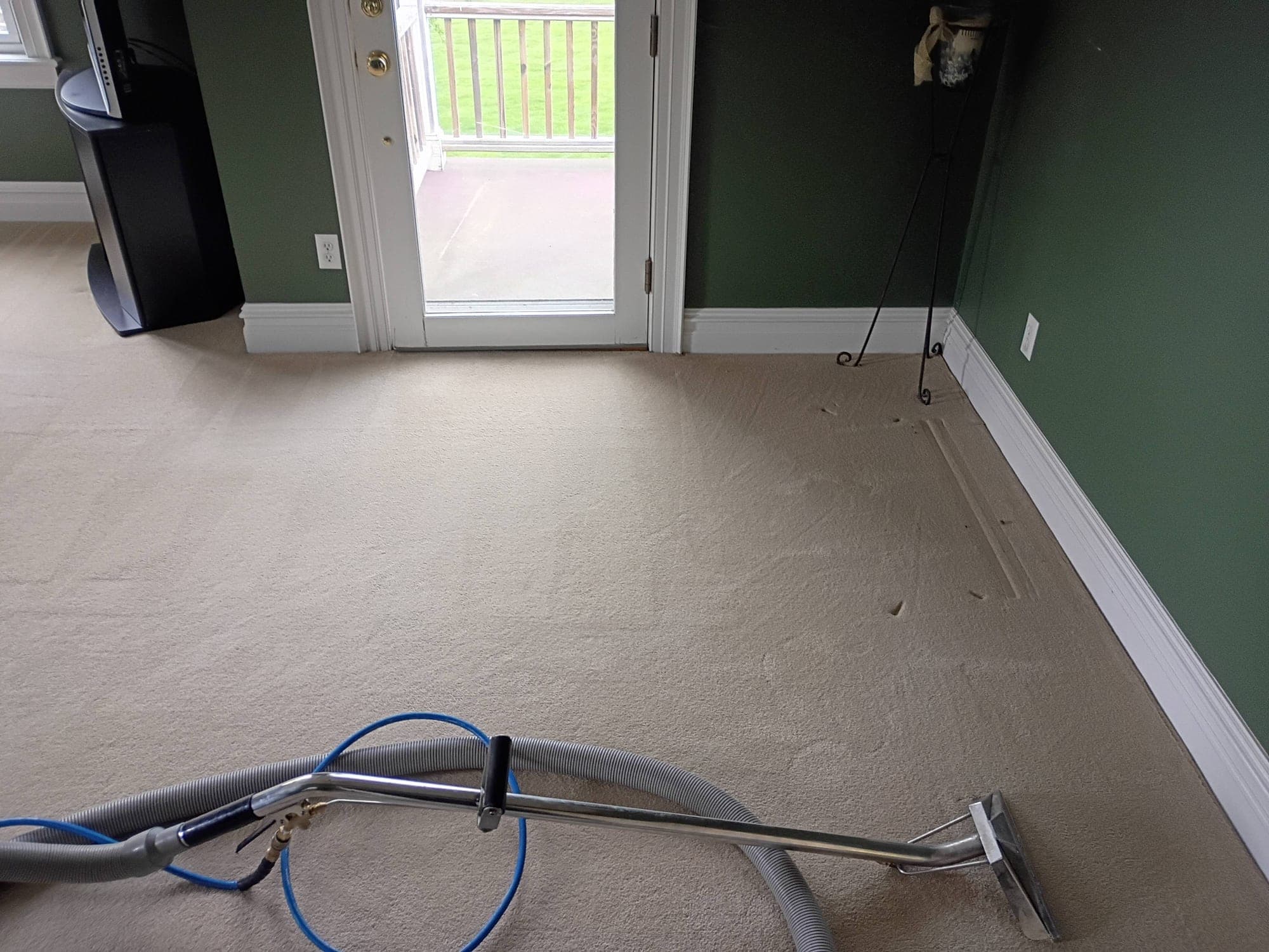 Carpet cleaning wand in use in a bright bedroom