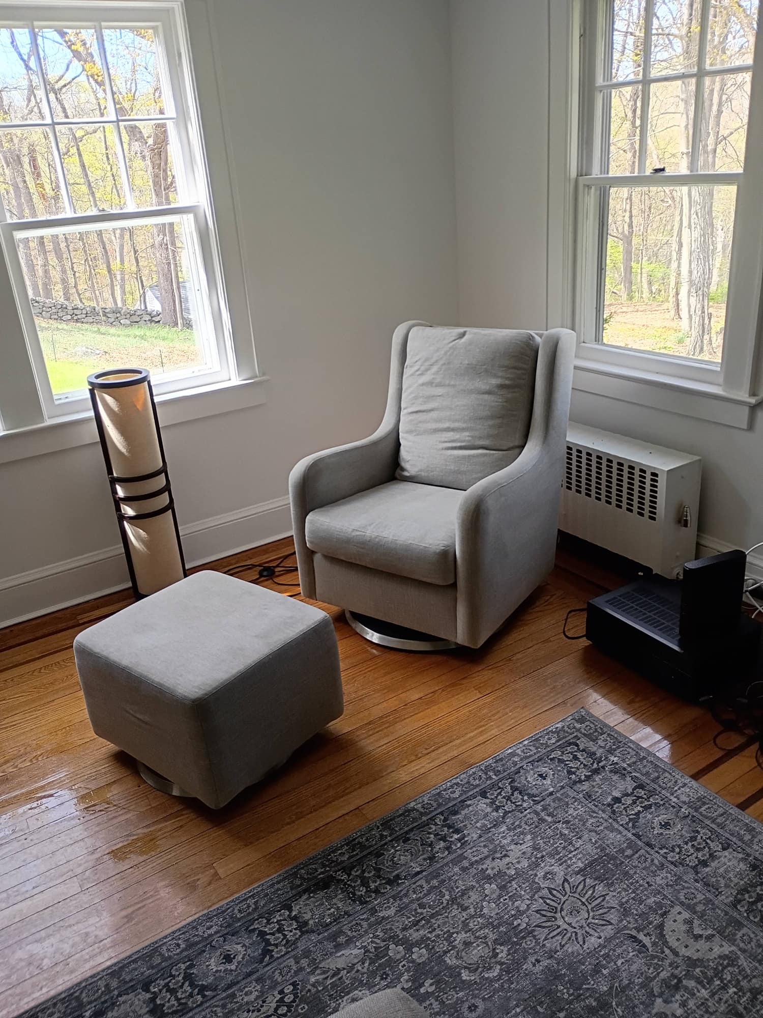 Cleaned gray armchair with ottoman in a sunlit window corner