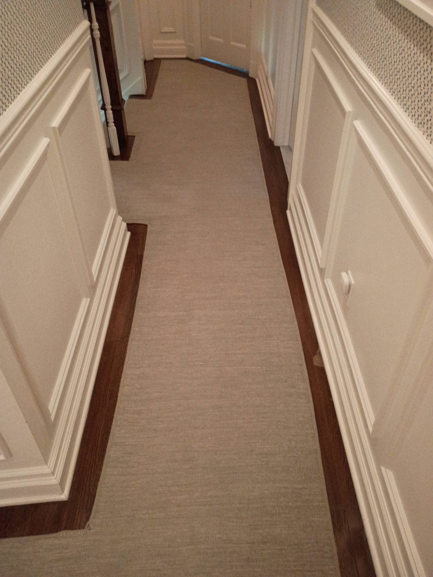 Hallway carpet runner near a staircase before cleaning