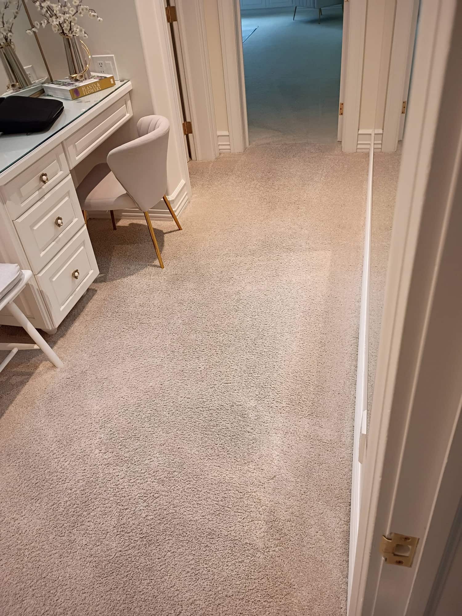 Long hallway carpet after cleaning leading toward a vanity area