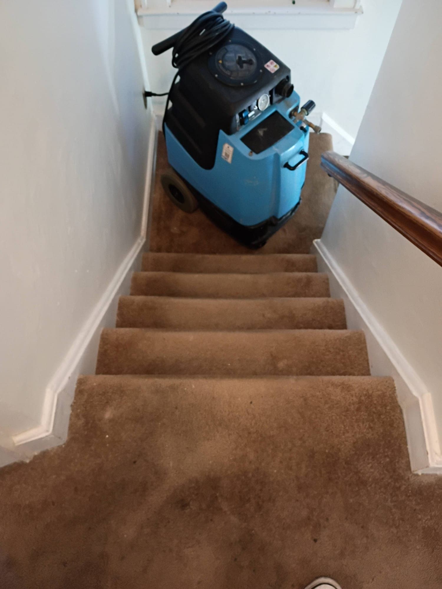 Stairs descending to a tile floor with extraction machine at the top