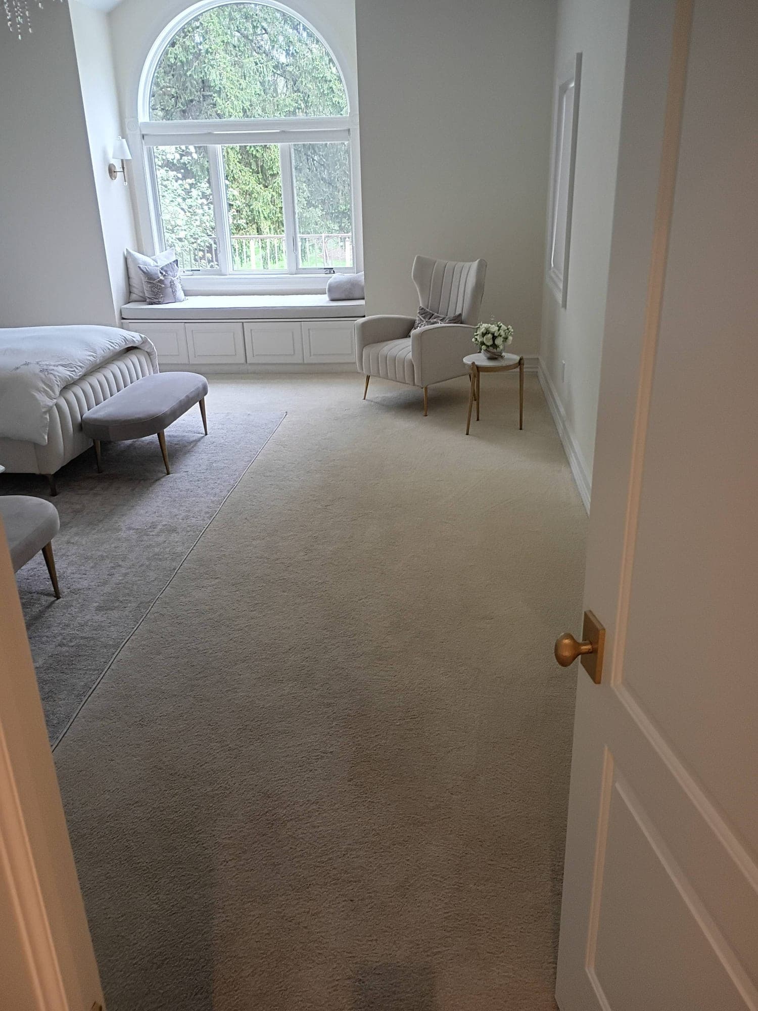 Bright bedroom with arched window seat and chair before carpet cleaning