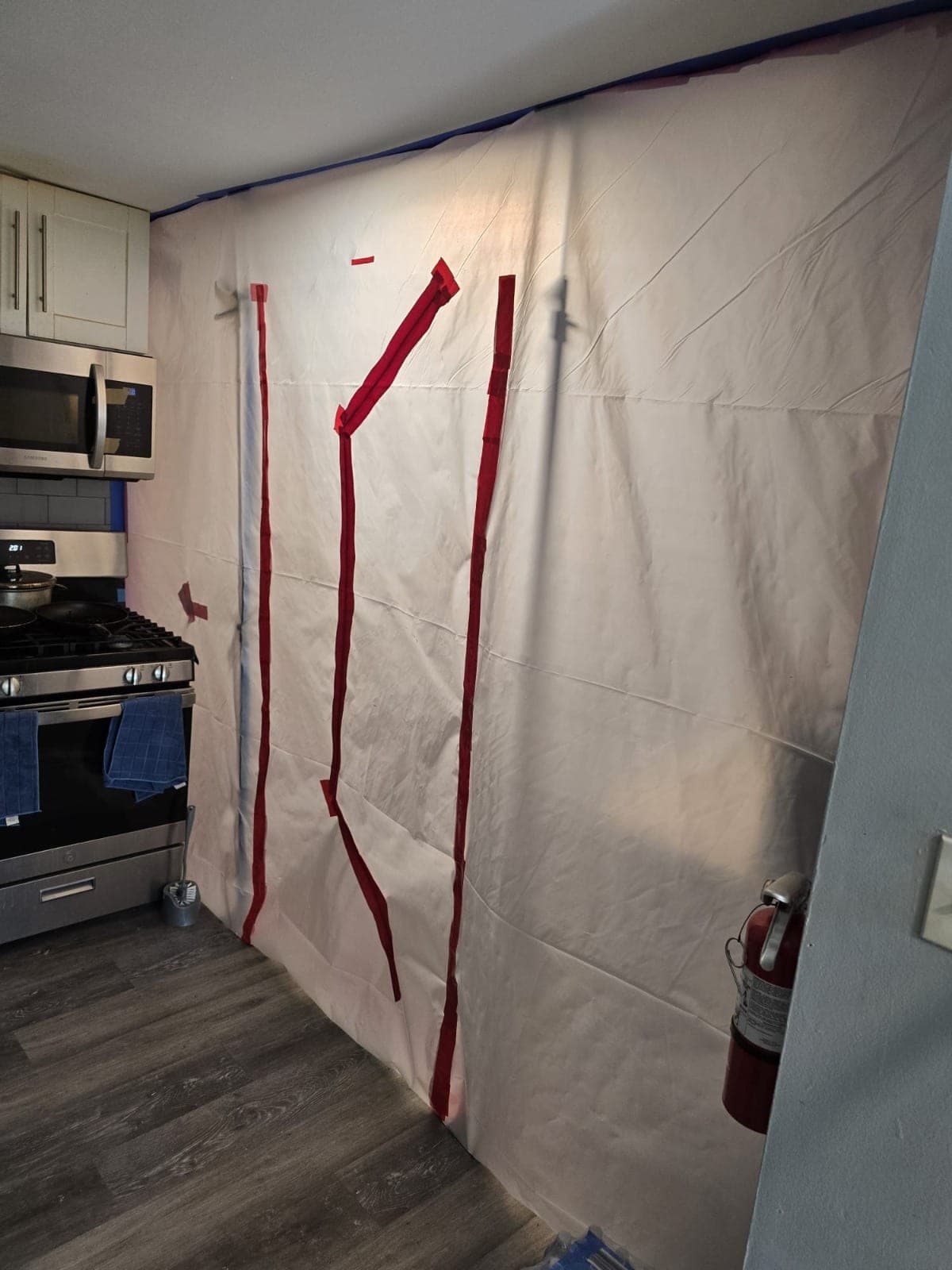 Kitchen wall sealed floor to ceiling with poly sheeting containment during water damage work